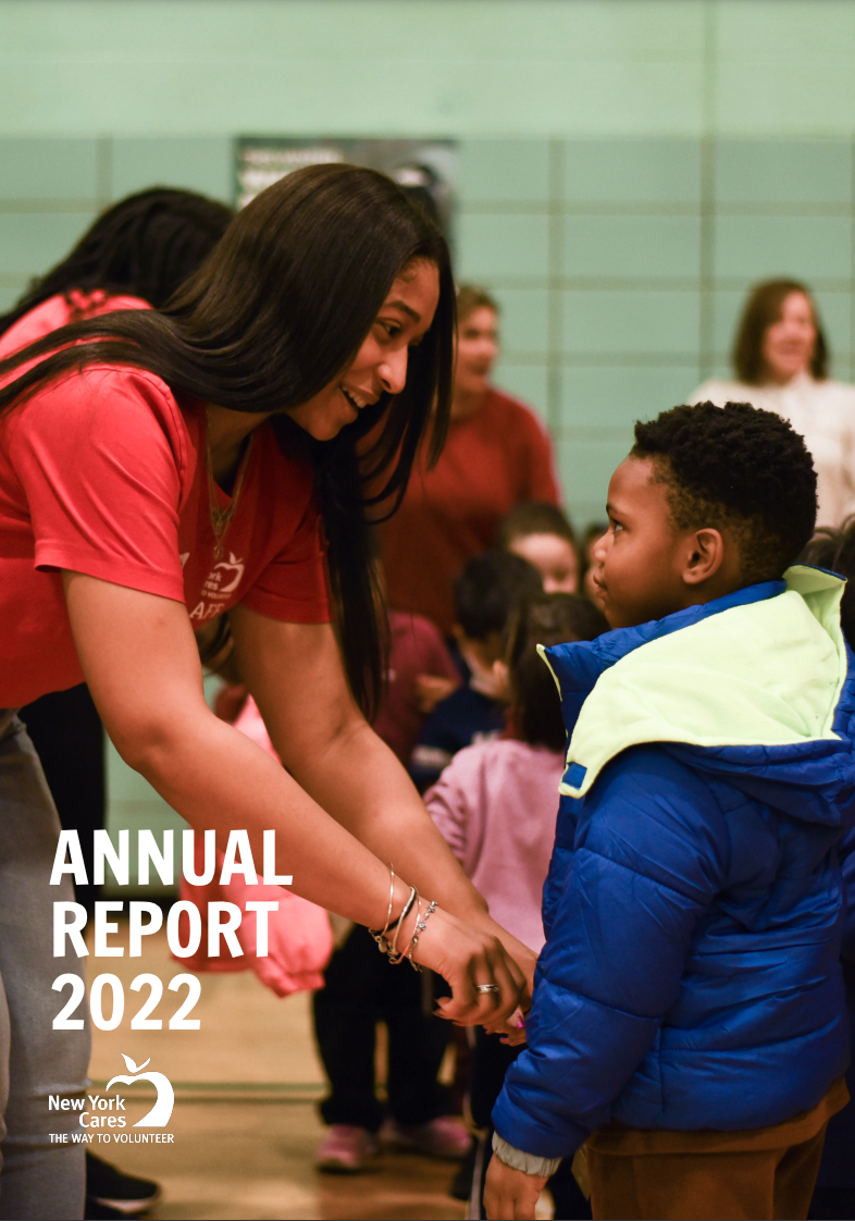 A woman in a red shirt zipping up the blue jacket on a young boy