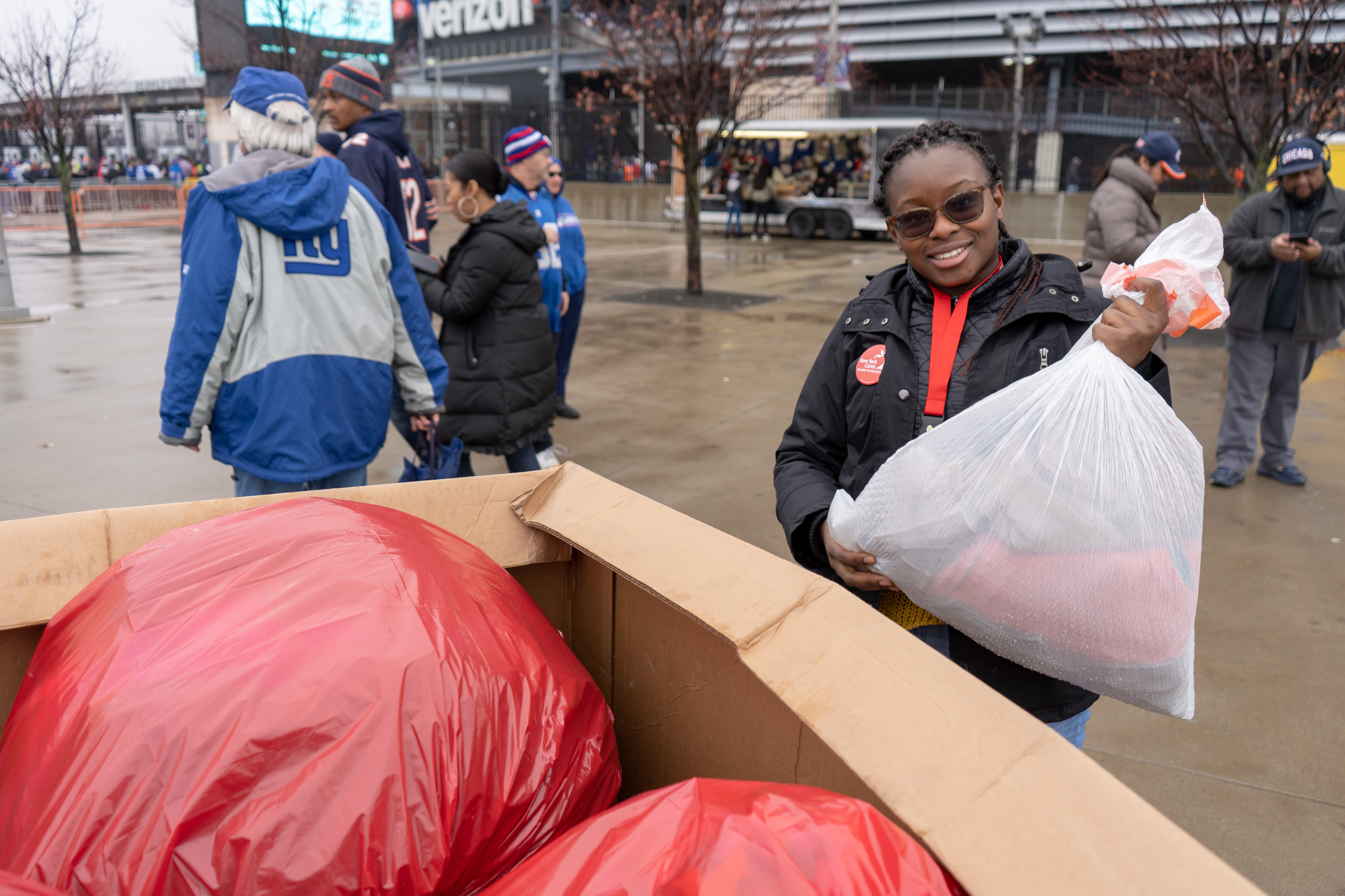 Volunteer putting coats in box at NY Giants Game