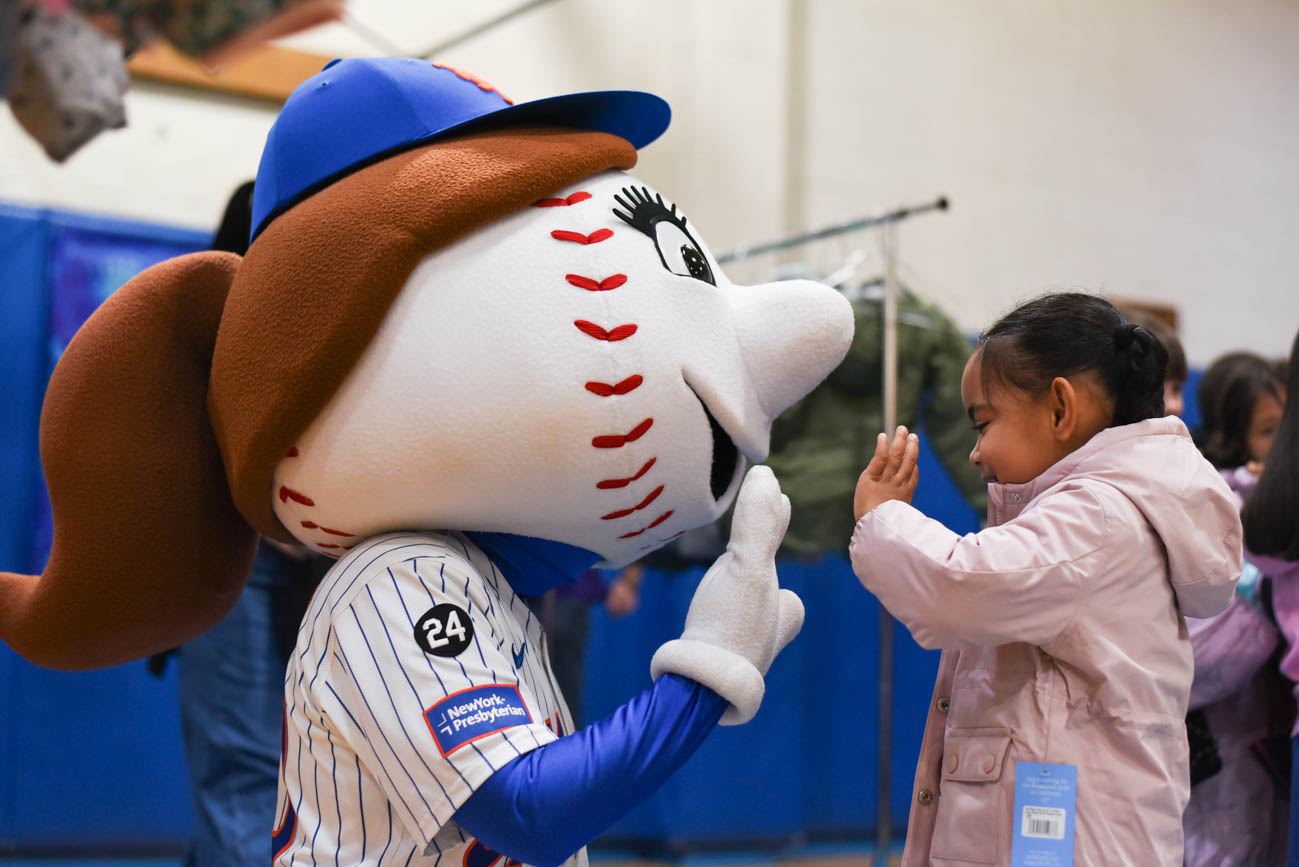 Mrs. Met high fiving a student who just received a coat