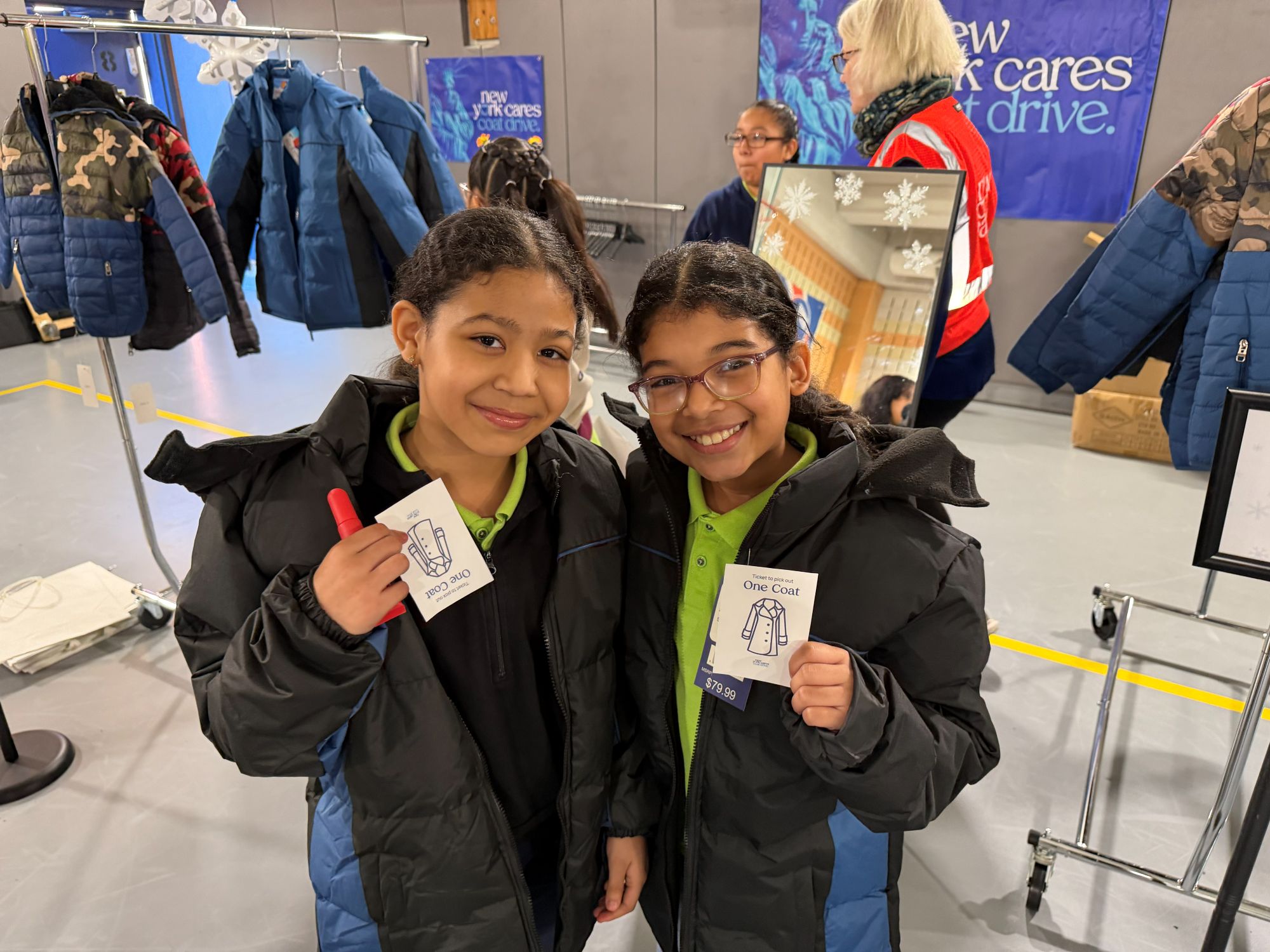 Two students posing with their coat tickets