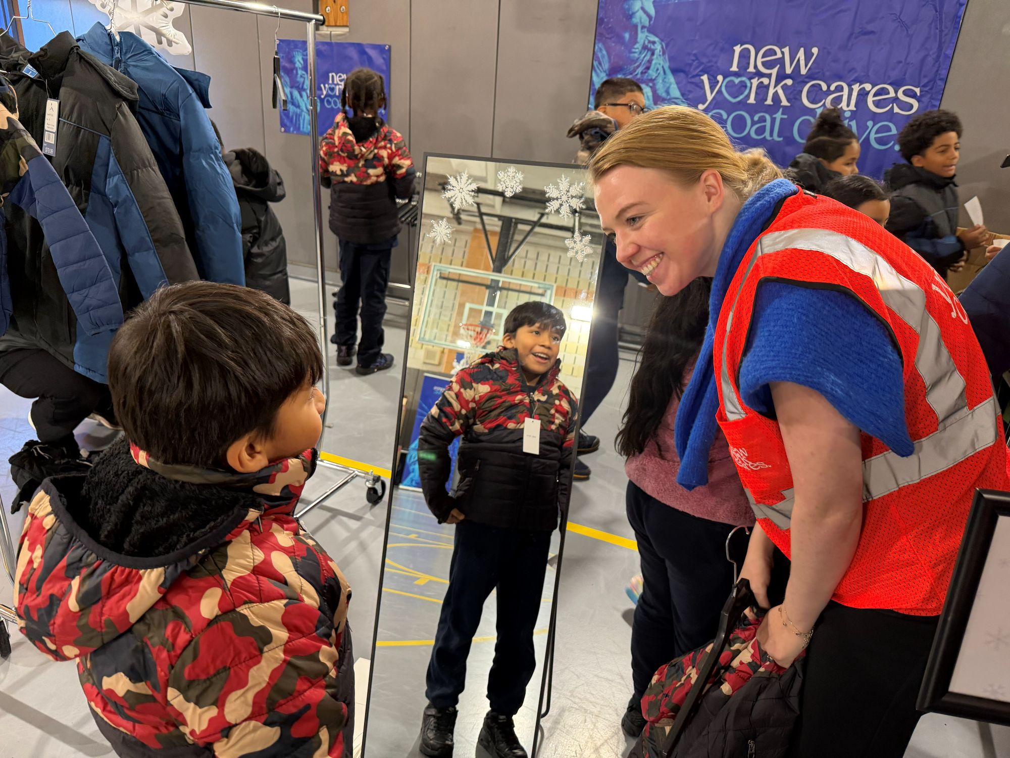 Volunteering helping a student try on a coat
